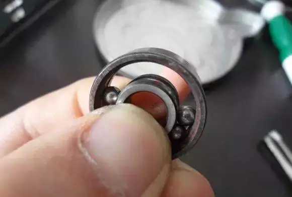 用手將軸承拿起，需要注意要向有滾珠的方向頂住